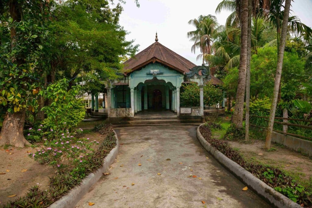 A traditional house nestled amid abundant green trees, showing natural surroundings and serene exterior