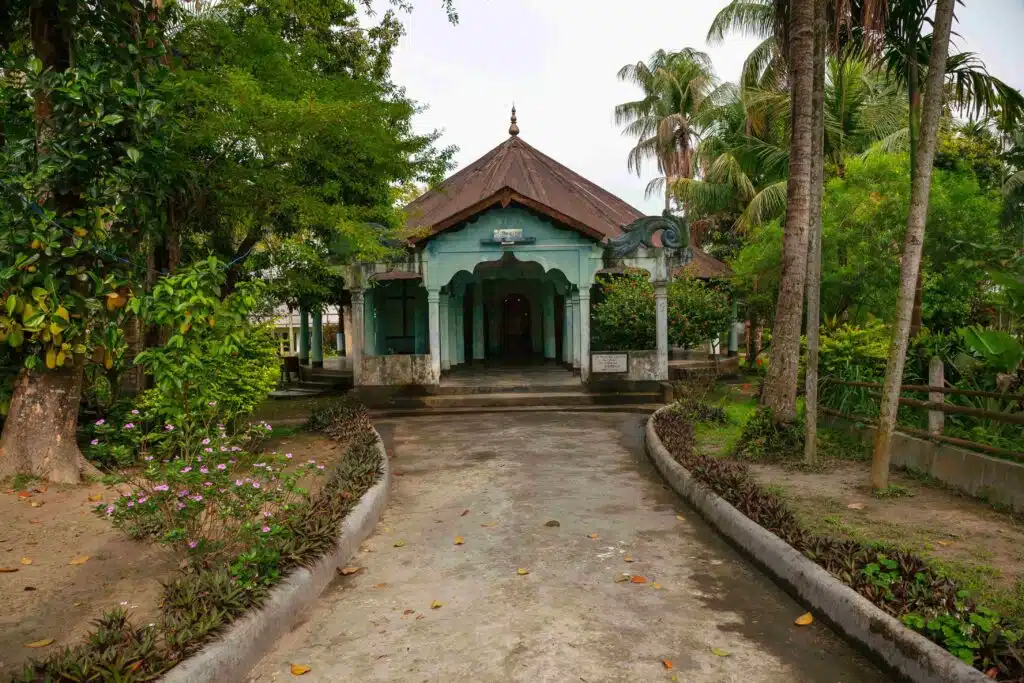 A traditional house nestled amid abundant green trees, showing natural surroundings and serene exterior